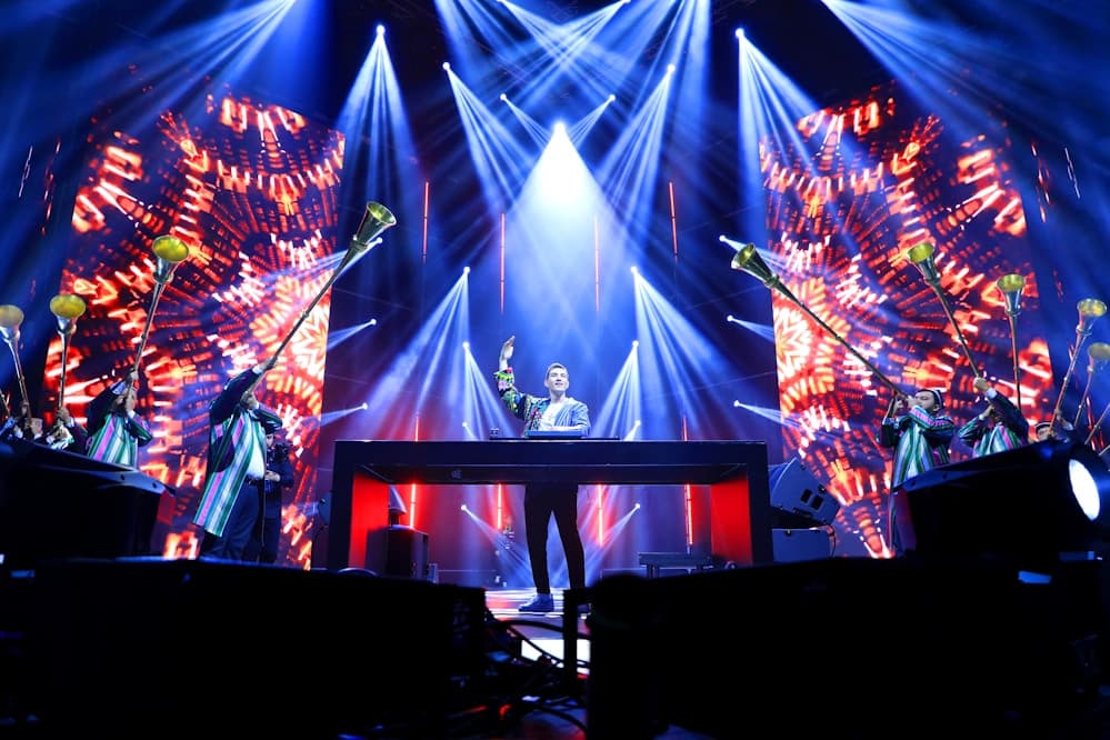 Wide shot of a concert venue with lights over the audience