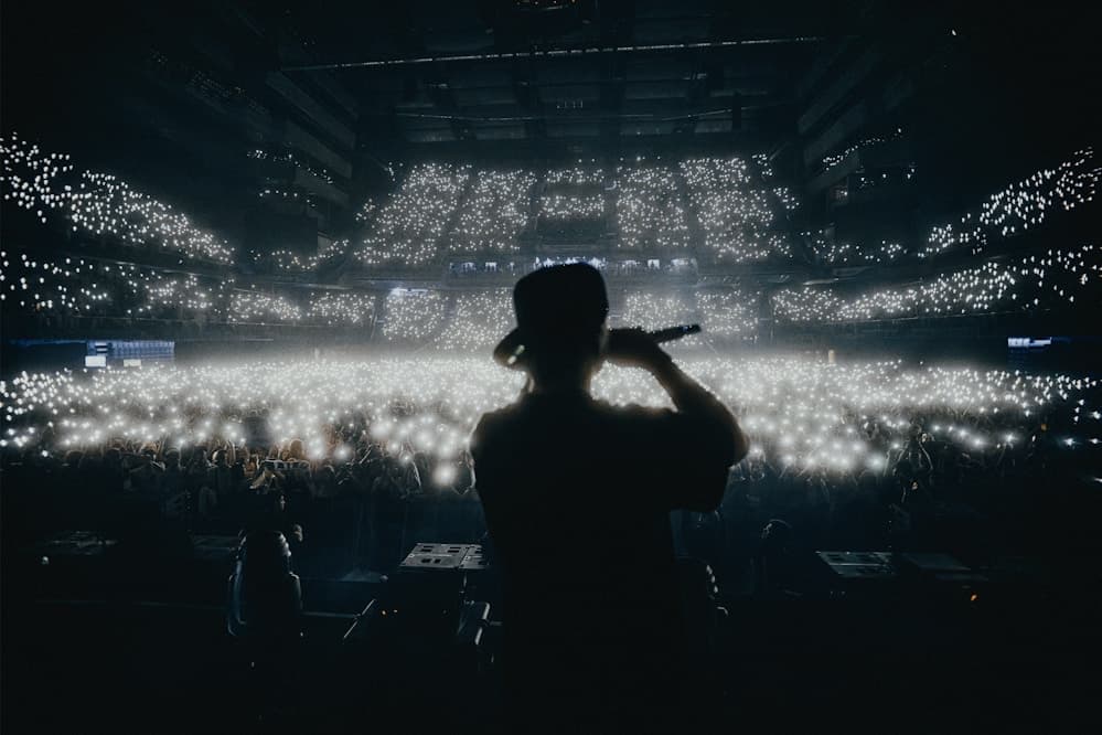 Performer singing on stage with colourful concert lighting