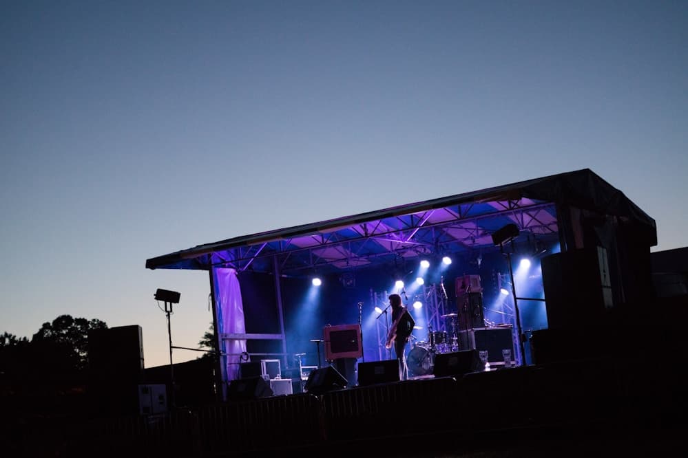 Musician playing guitar on stage under spotlights