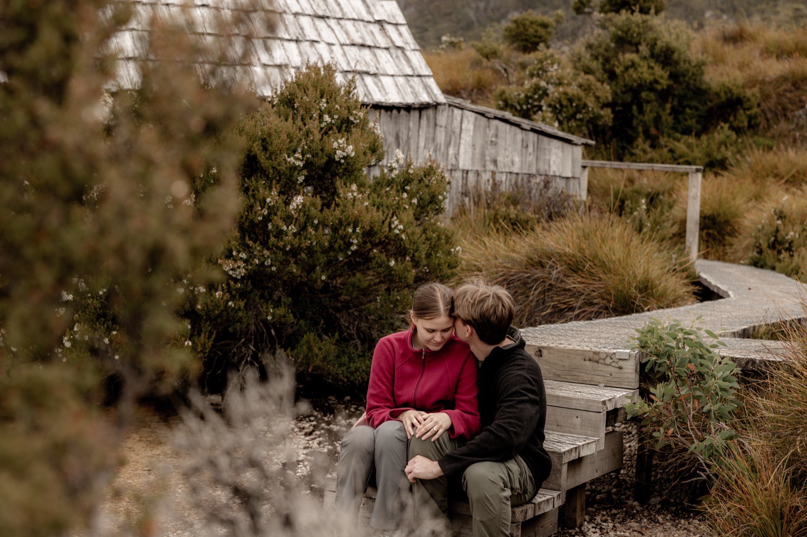 Couple sitting together on the boardwalk steps beside the Dove Lake boatshed
